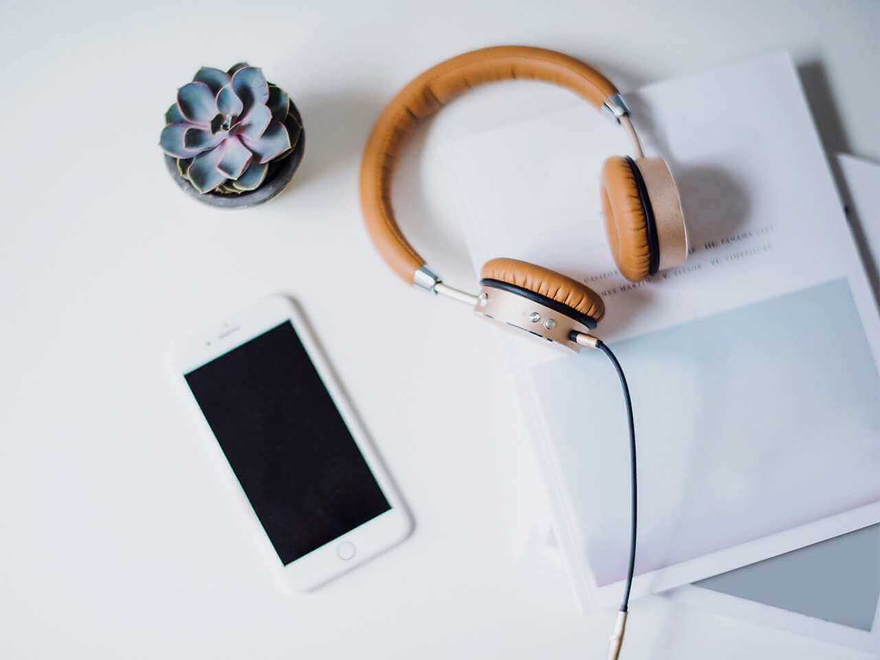 Tidy workspace with headphones, smartphone and notebook